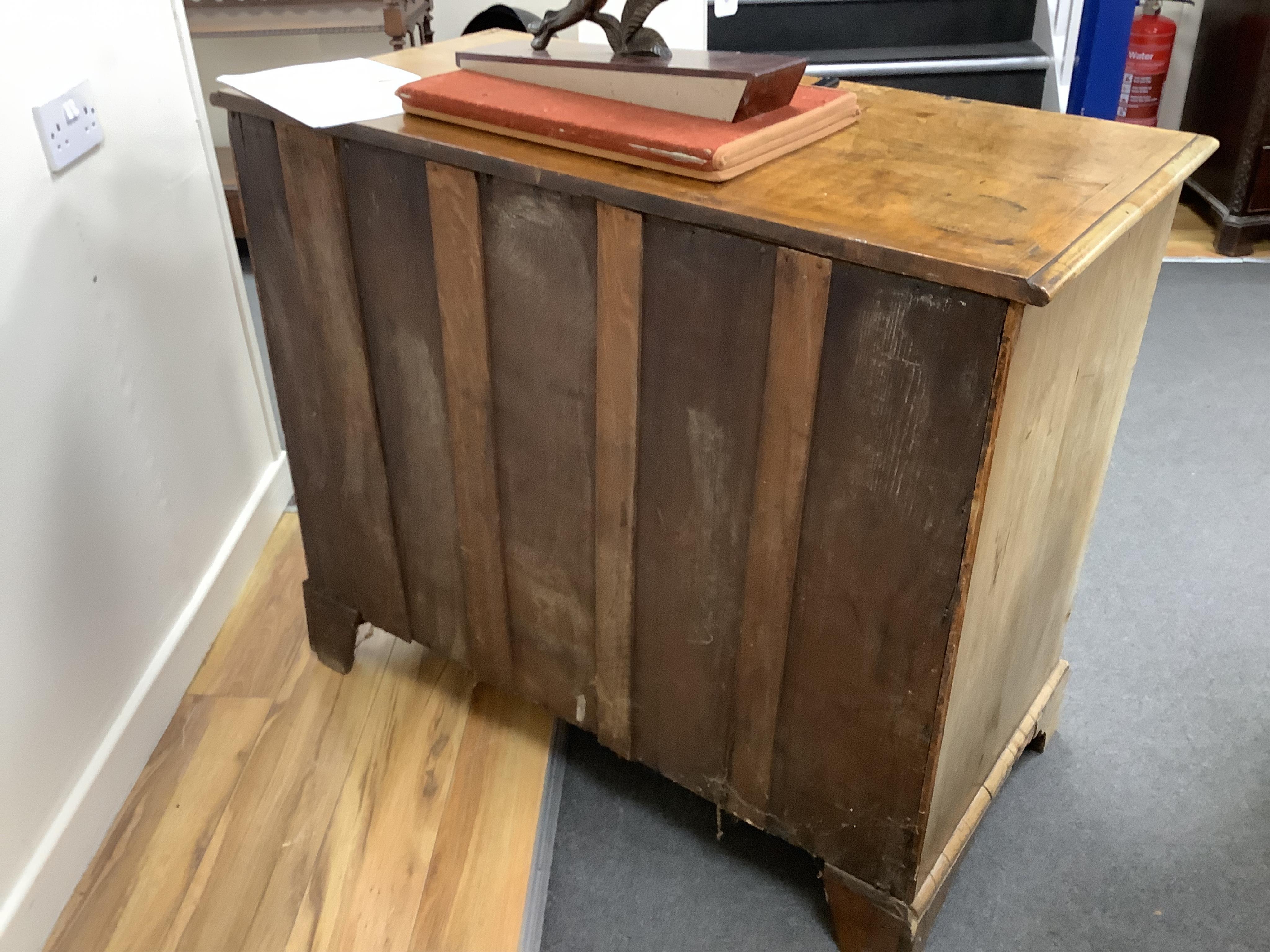 A mid 18th century feather banded walnut concave starburst walnut chest of three drawers, with brushing slide, width 108cm, depth 54cm, height 92cm